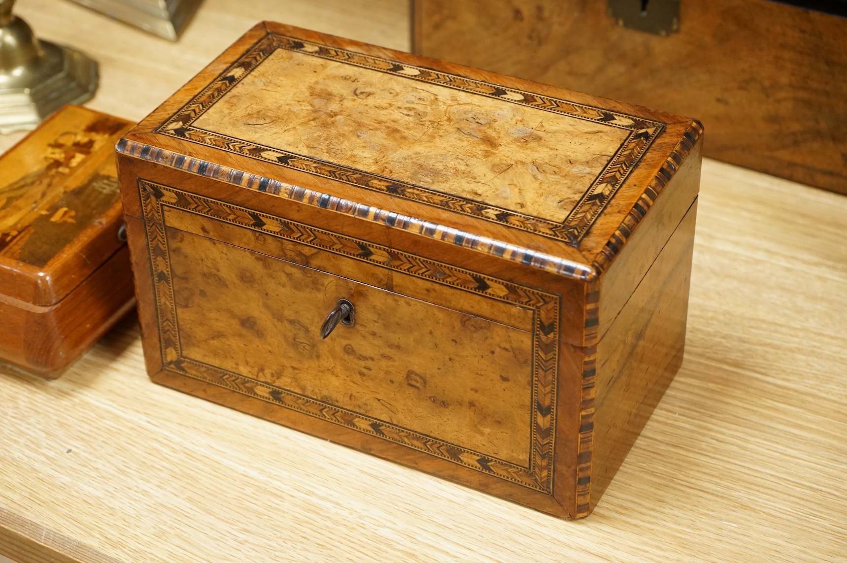 A walnut and German bandwork tea caddy, a brass bound walnut writing slope and an Art Deco Killarney inlaid trinket box, largest 15cm high, 30cm wide.